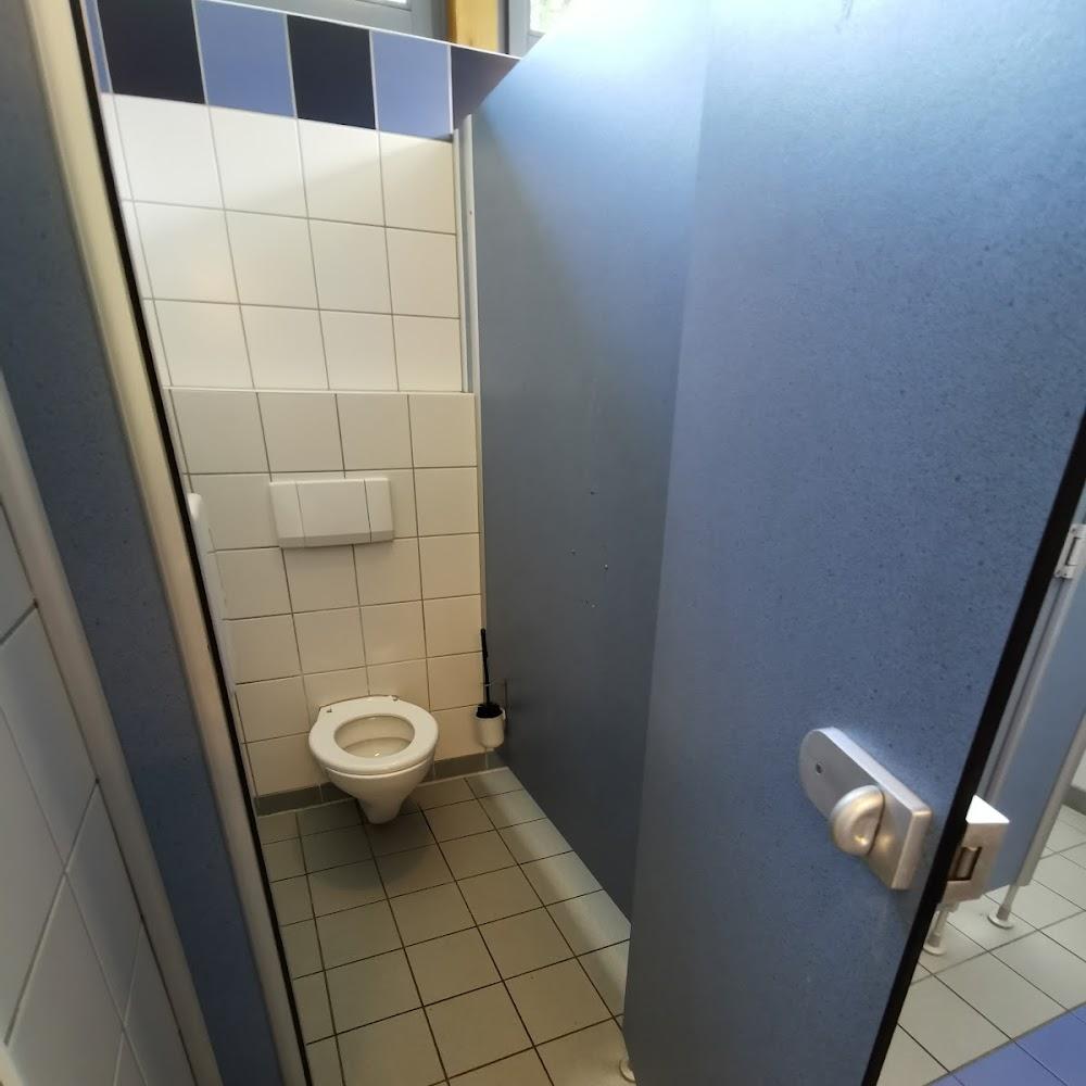 A toilet stall in a bathroom with a toilet.